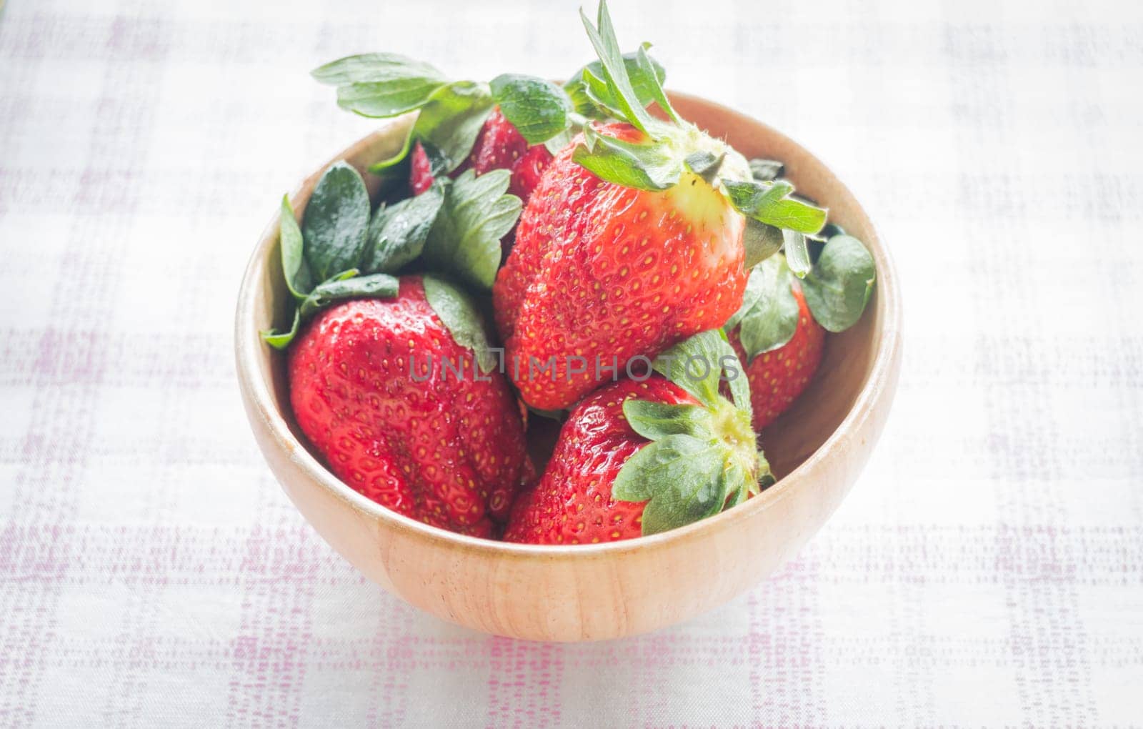 Fresh strawberry on wooden bowl, stock photo