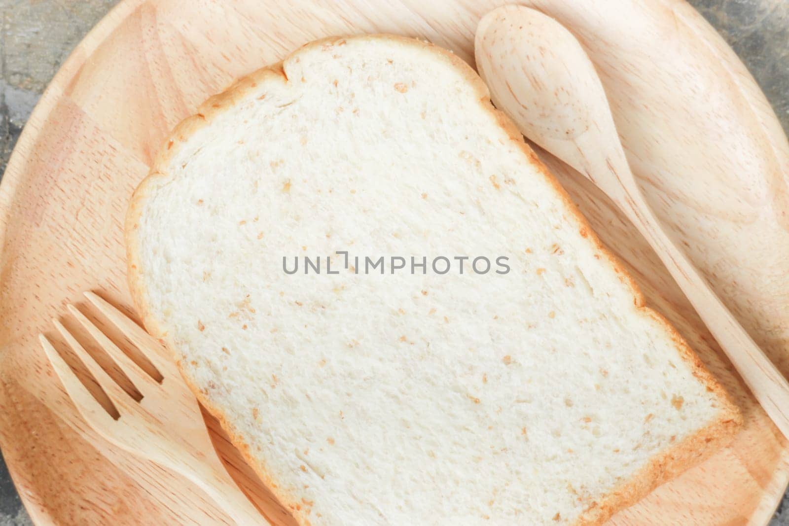 Sliced of whole wheat bread on wooden plate, stock photo