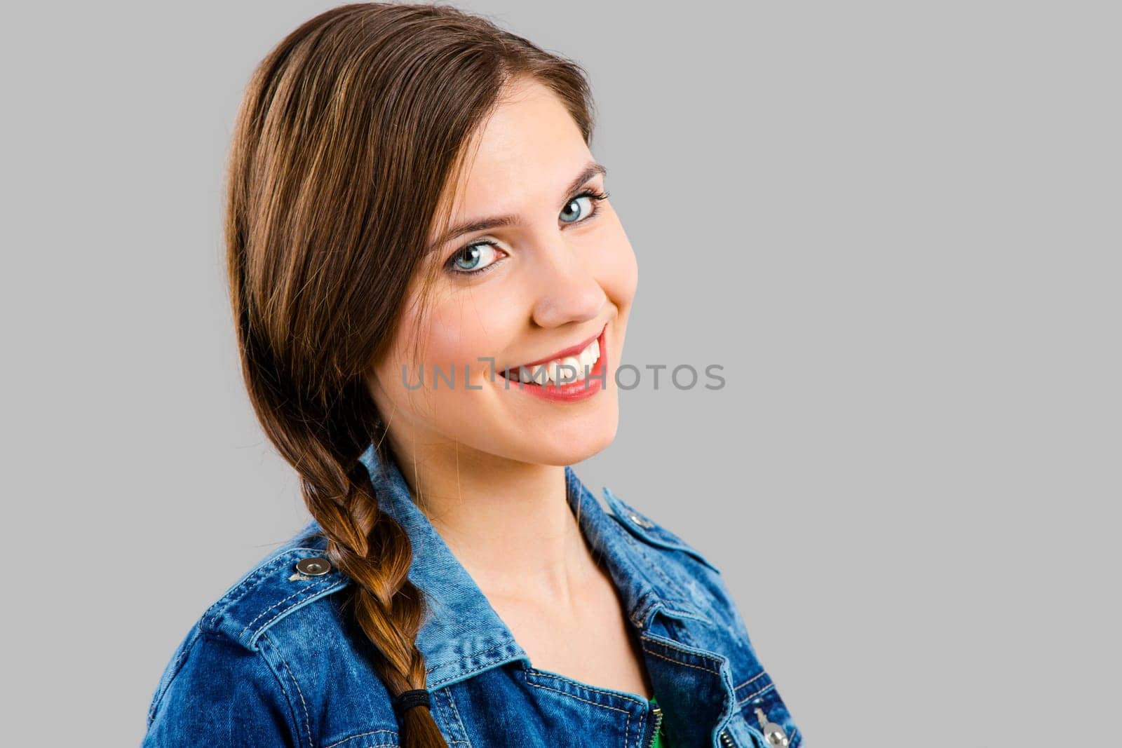 Portrait of a beautiful woman smiling over a grey background