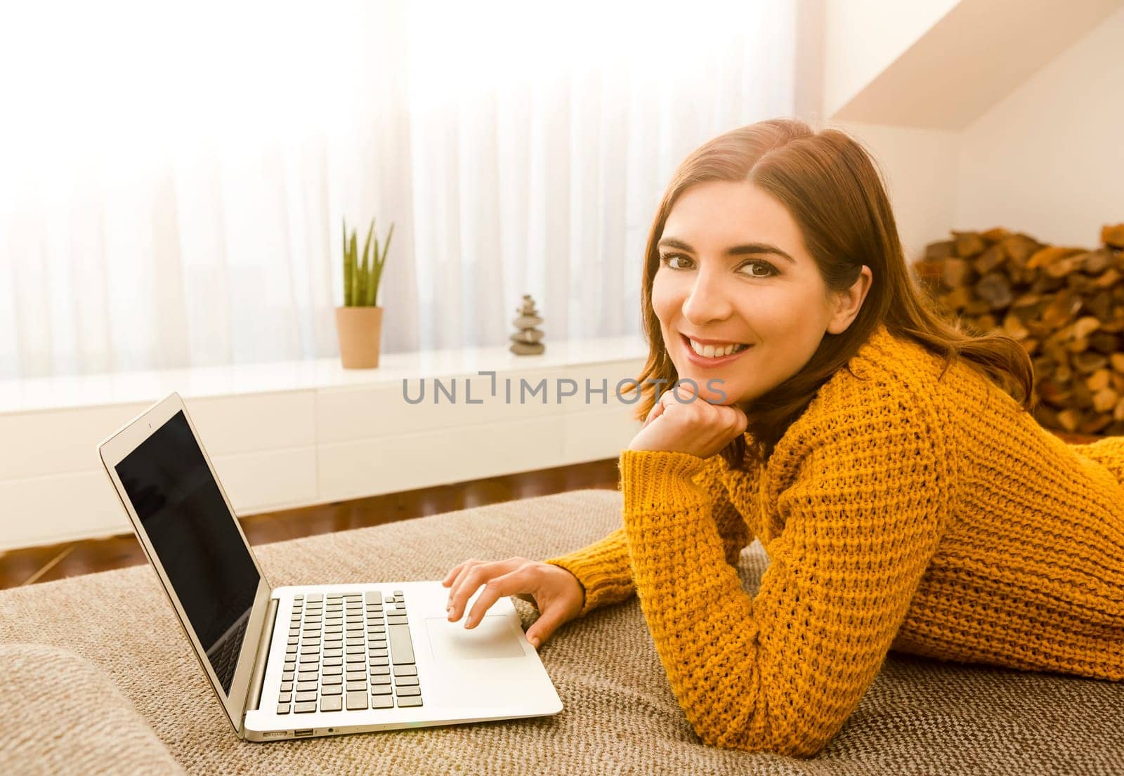 Beautiful woman working from the confort of home with her laptop