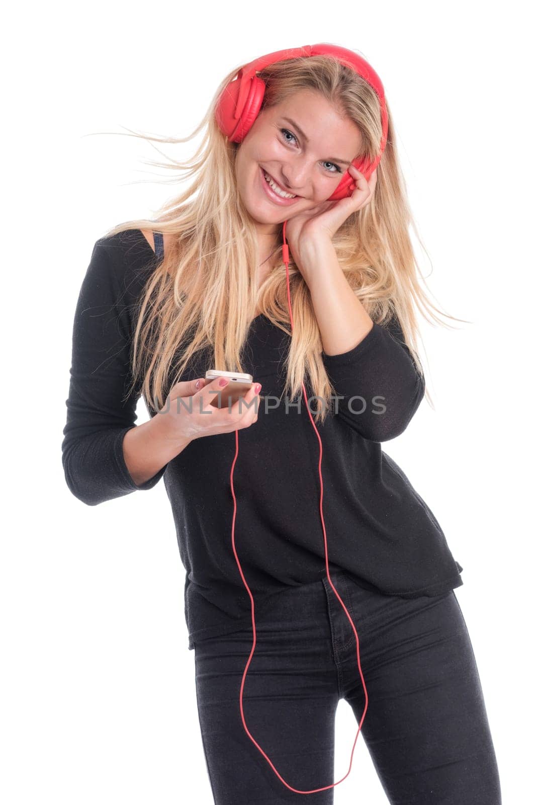 Young woman listens to music through headphones and smiles