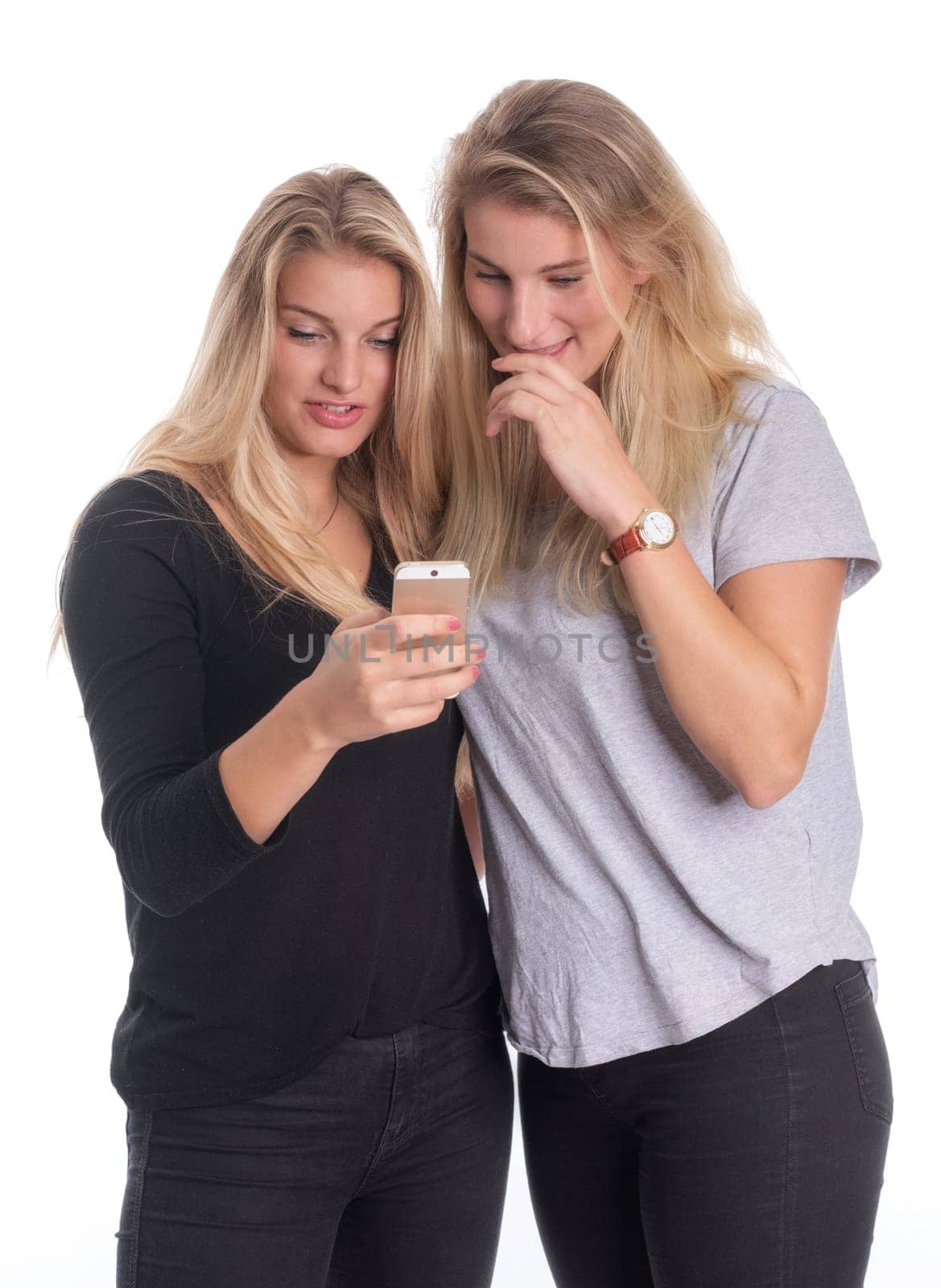 Two blonde girlfriends look at a mobile phone message together