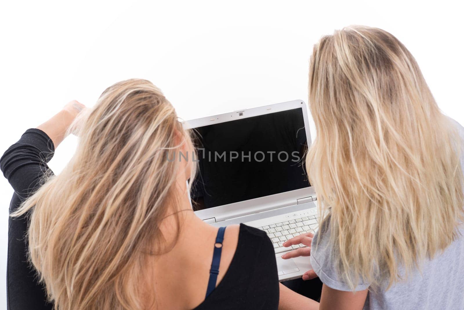 2 blonde girls sitting together on laptop