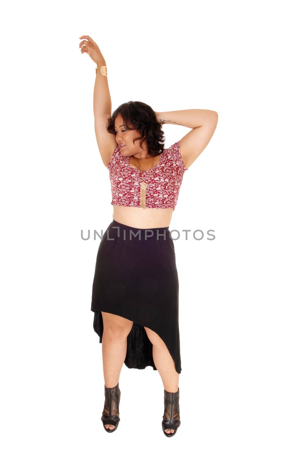 A mixed raced young woman standing isolated for white background.in a black skirt, lifting one arm up.