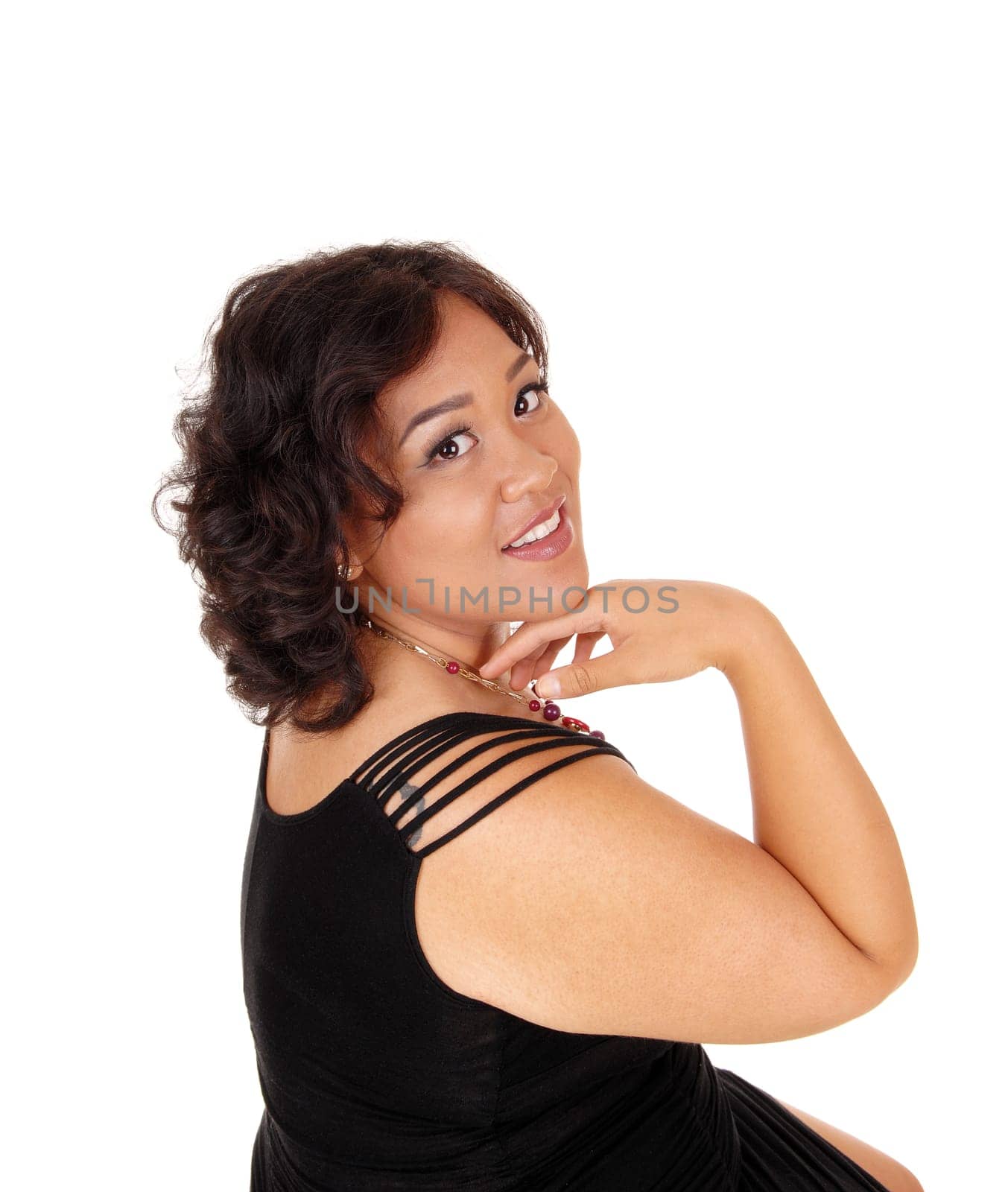 A beautiful young mixed raced woman in a black dress with her hand under.her chin, isolated for white background..