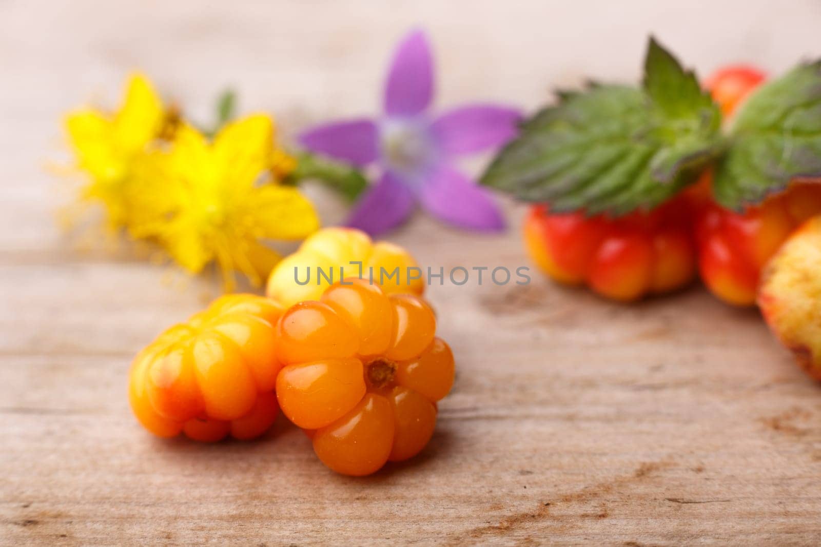 Cloudberries (moroshka) on a wooden table. Wild northern berry. Shallow depth of field