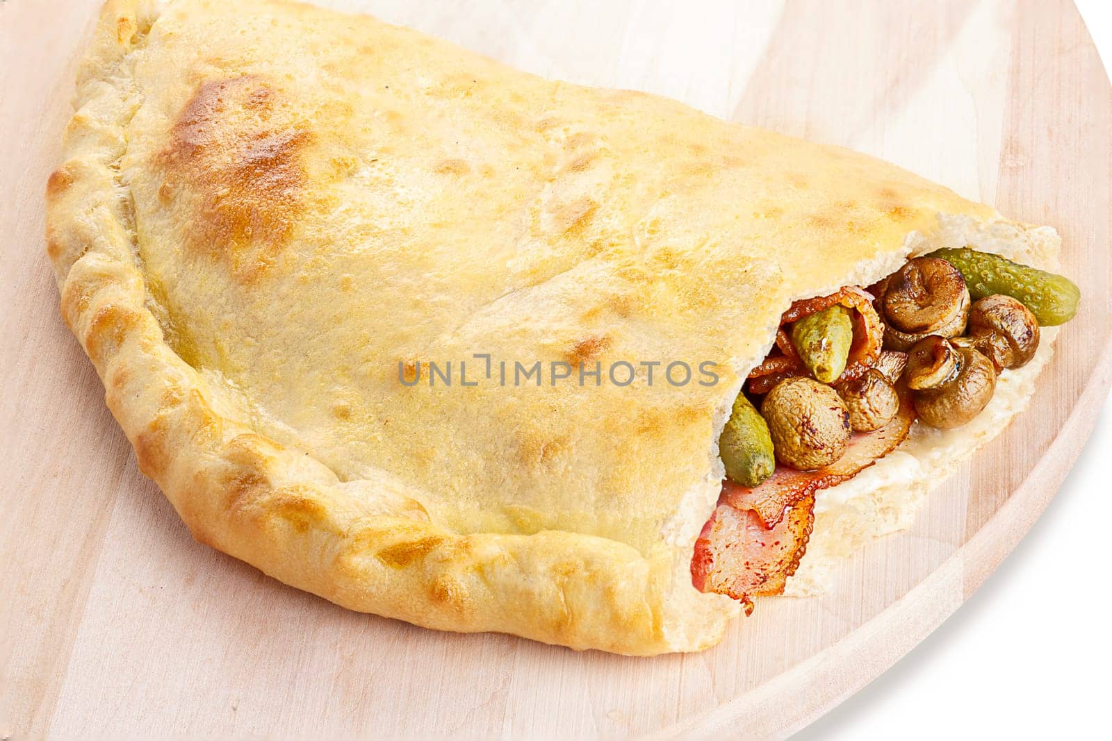 Neat, tasty and elegant closed pizza (calzone) stuffed with bacon,mushrooms and gherkins