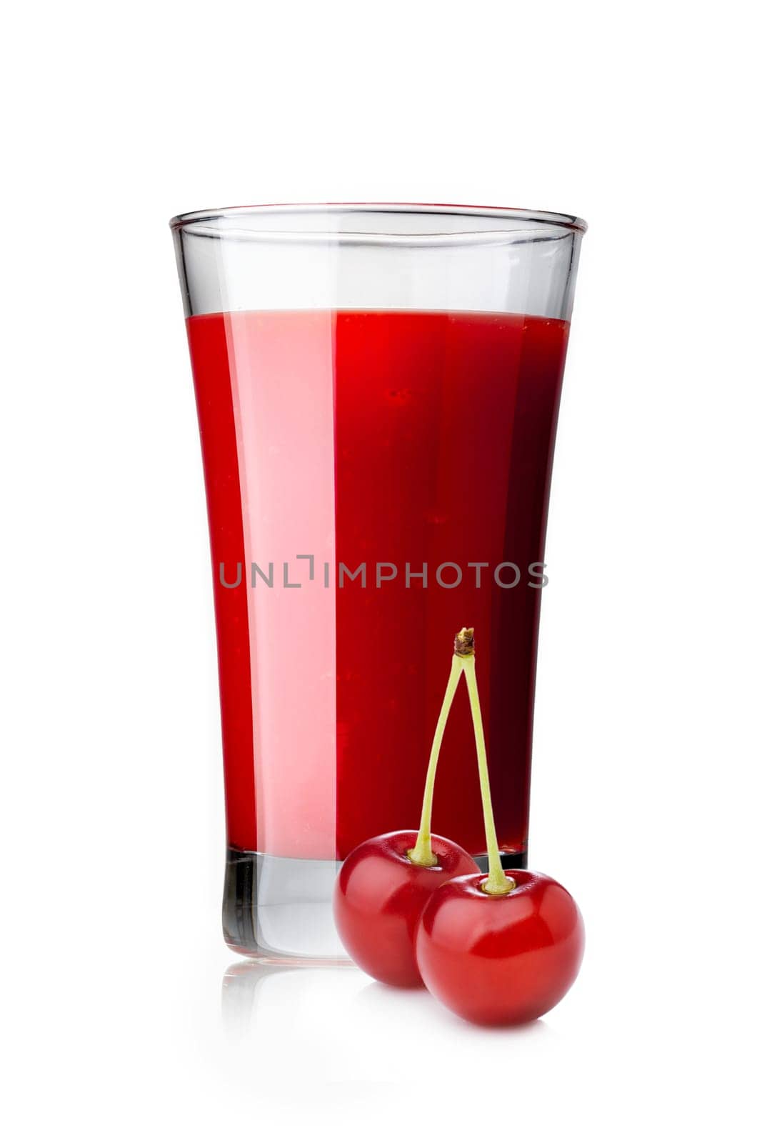 Fresh sour cherry  juice in highball glass with cherries on foreground isolated on white