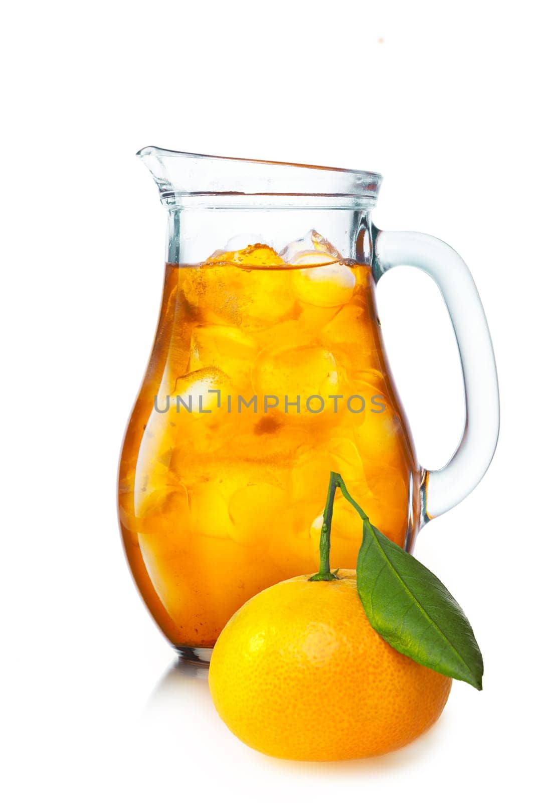 Tangerine lemonade with ice in a pitcher. Jug full of iced tangerine drink.