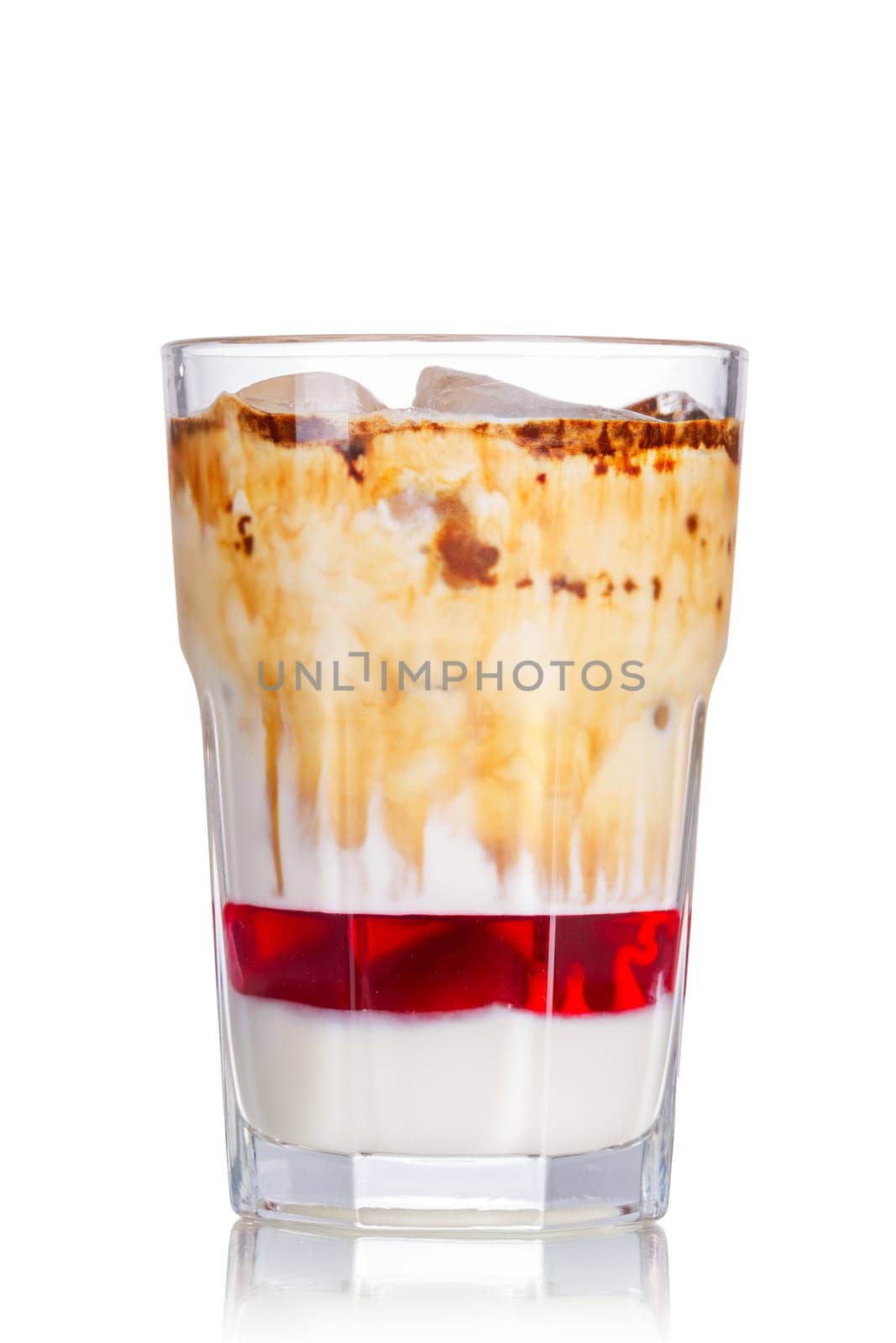 Layered iced milkshake with strawberry syrup, condensed milk and chocolate. Delicious milk cocktail in highball glass