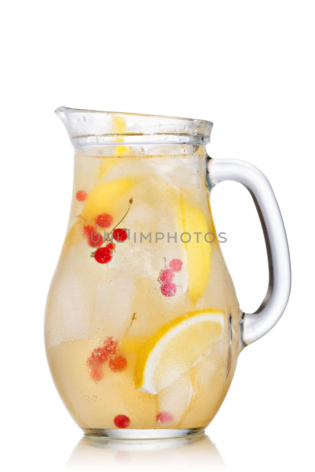Jug of sparkling lemonade (spritzer). Carbonated iced water with lemon and red currant in a glass pitcher