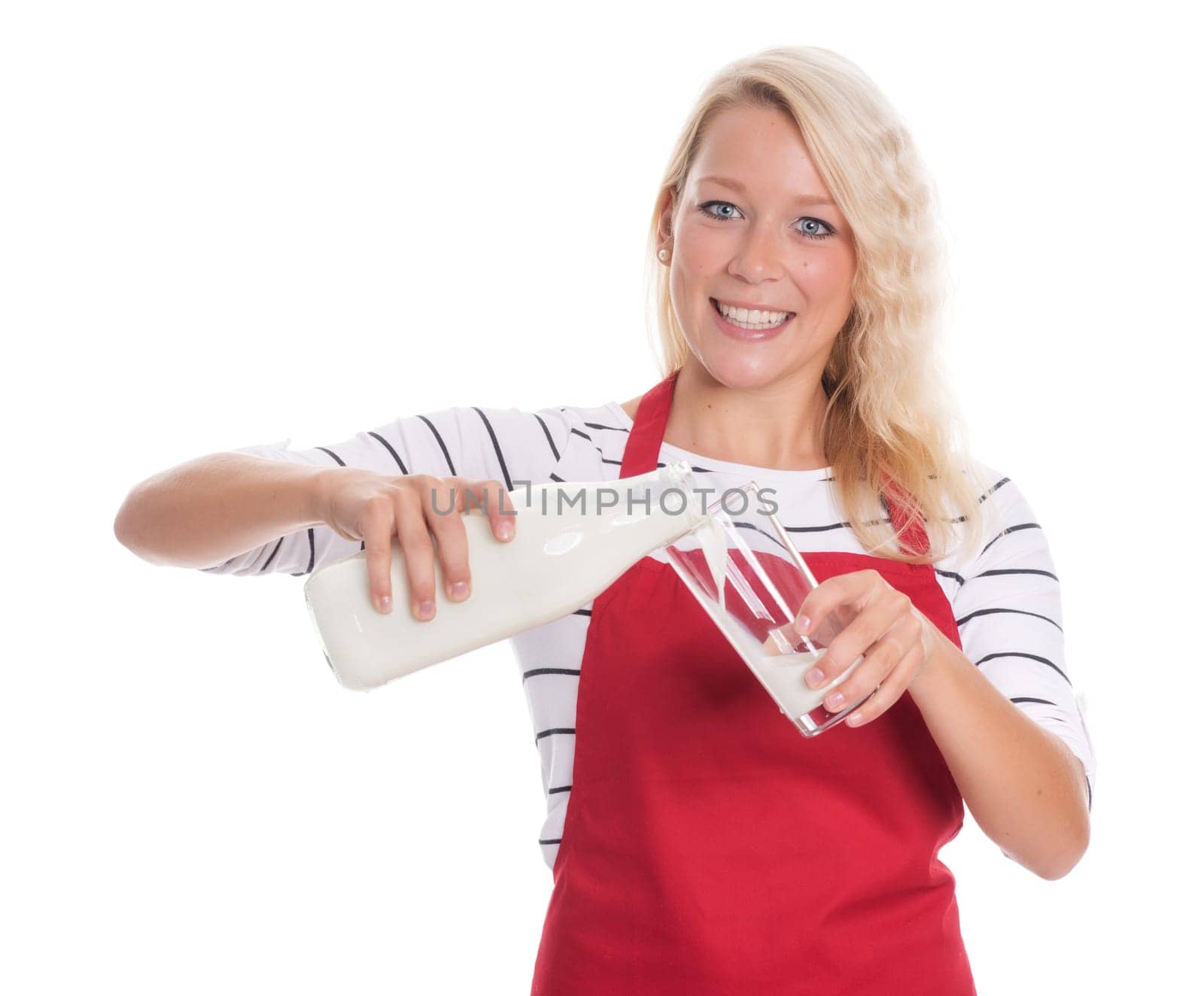 Woman in red apron pours a glass of milk