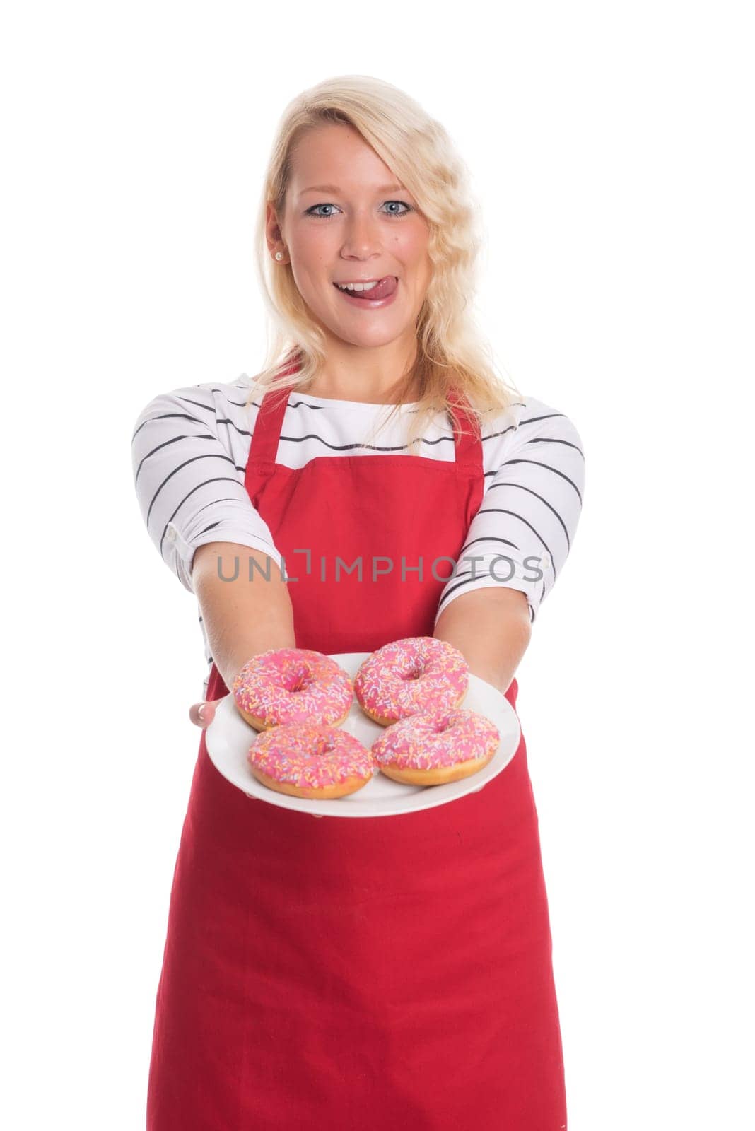 Blonde woman in apron holds plate with doughnuts