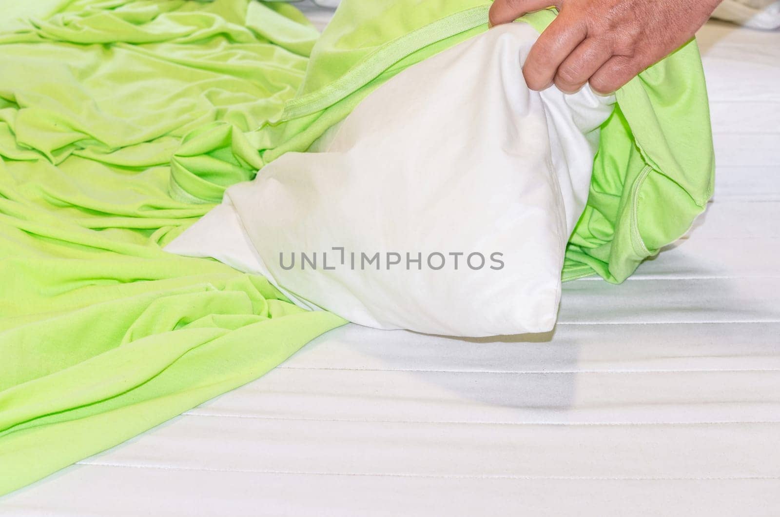 Close up on green bedding. Bed linen and pillows,are re-covered. Bed concept