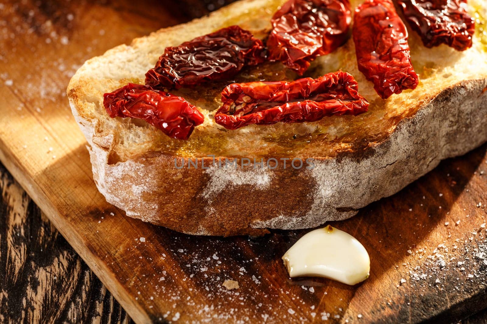 Bruschetta with dried tomatoes, garlic and olive oil. Traditional Italian cuisine sandwich made of grilled ciabatta. Antipasti