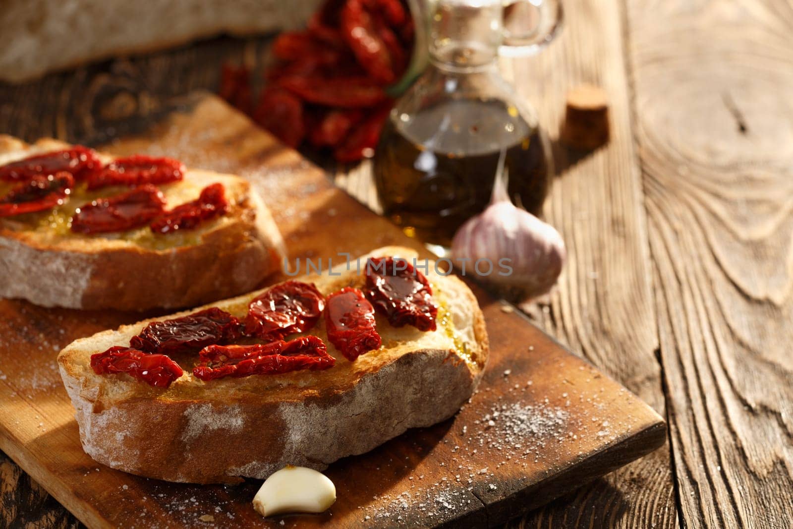 Bruschetta with dried tomatoes, garlic and olive oil. Traditional Italian cuisine sandwich made of grilled ciabatta. Antipasti