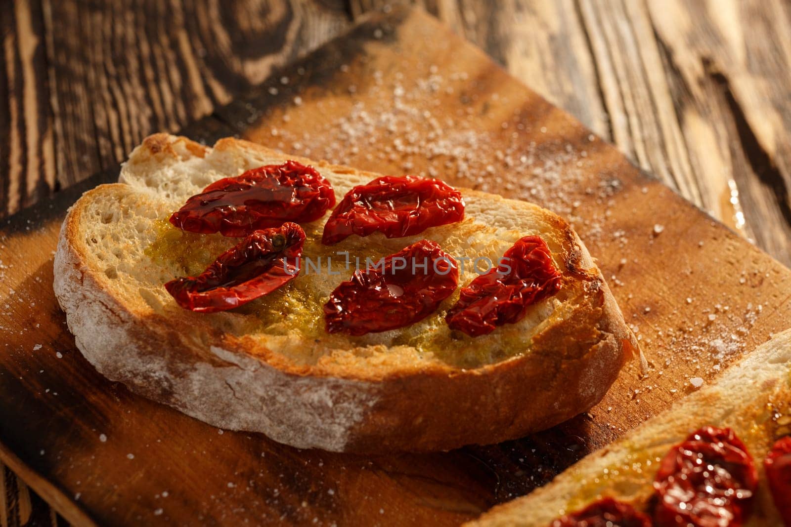 Bruschetta with dried tomatoes, garlic and olive oil. Traditional Italian cuisine sandwich made of grilled ciabatta. Antipasti