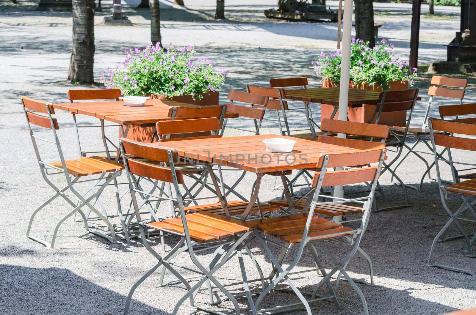 Table and chairs in the outdoor area of a restaurant. Beer garden awaits its guests.