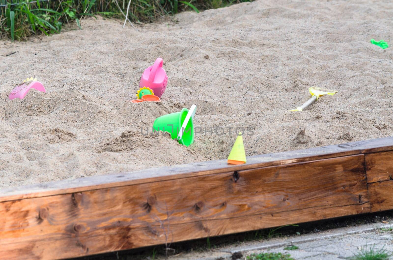 Large sandbox with various plastic toys.