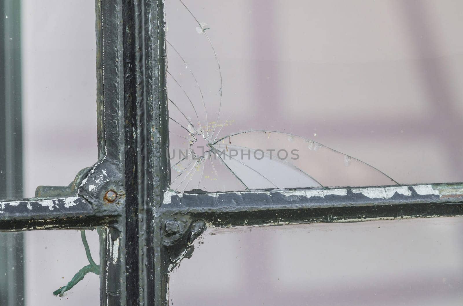 A hole in the window pane. A broken glass pane - pierced by ball.