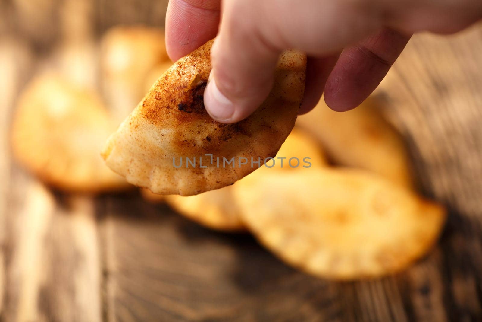 Male hand holding fried colombian empanada. Savory stuffed patties also known as pastel,pate or pirozhki
