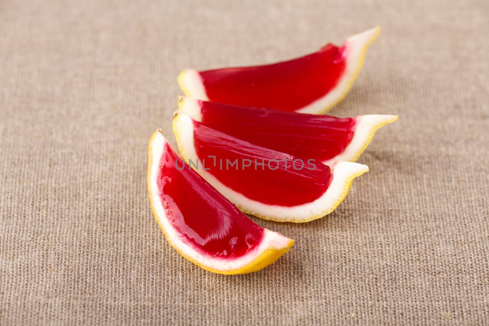 Lemon tequila strawberry jelly (jello) shots on a linen clothed table. Unusual adult party drinks