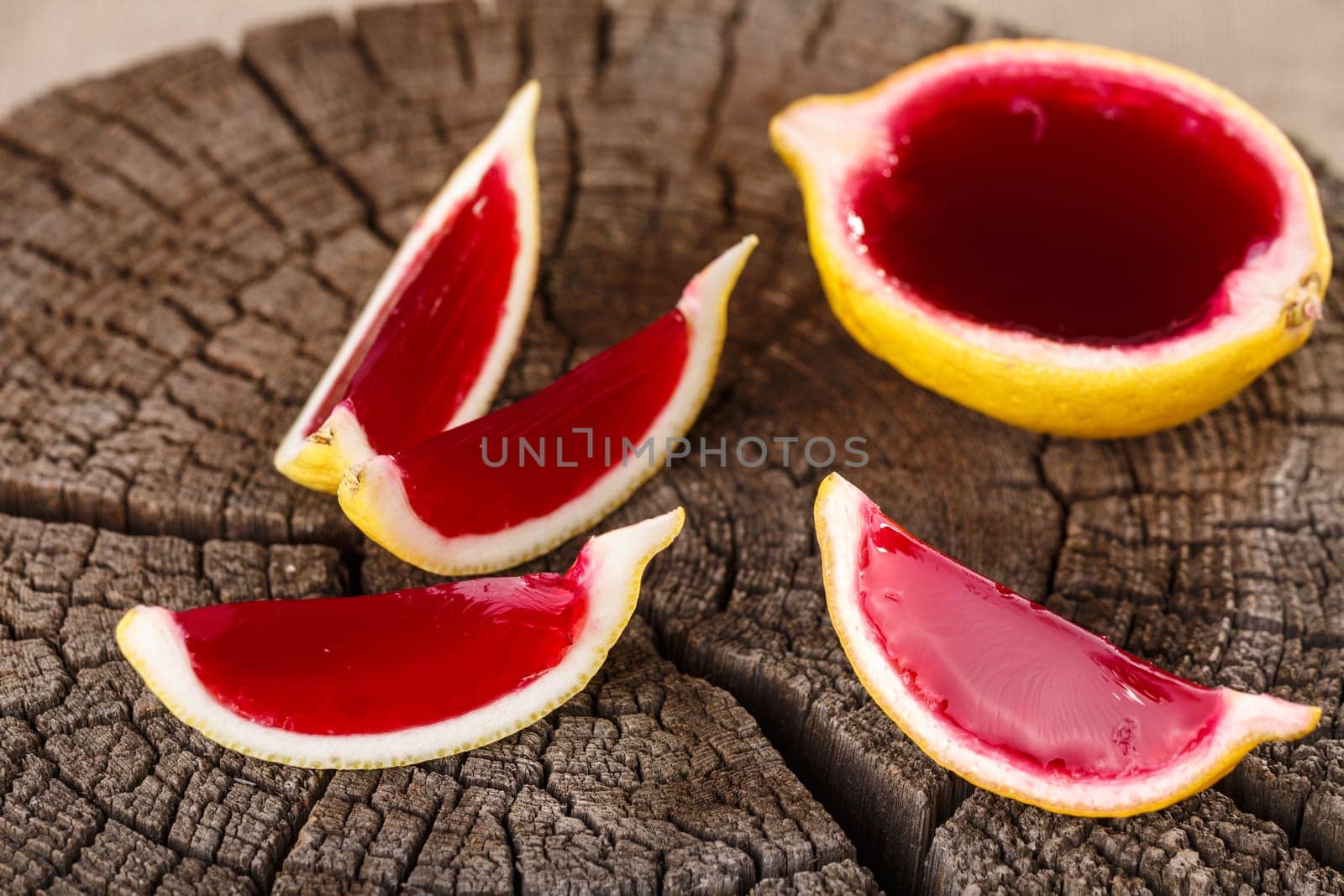 Lemon tequila strawberry jelly (jello) shots on a old wooden wheel. Unusual adult party drink