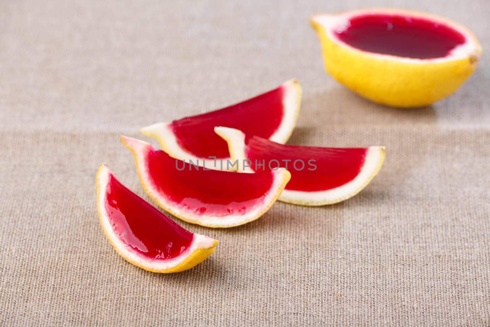 Lemon tequila strawberry jelly (jello) shots on a linen clothed table. Unusual adult party drinks