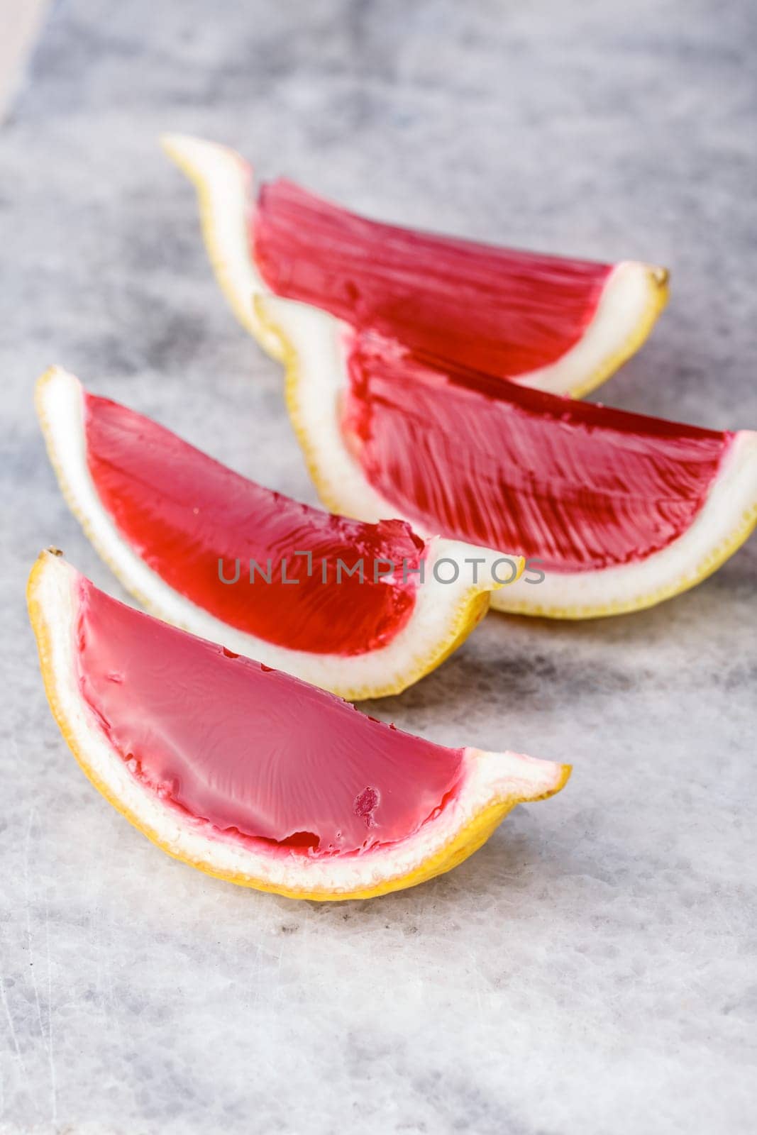 Lemon tequila strawberry jelly (jello) shots on a marble plate. Unusual adult party drinks
