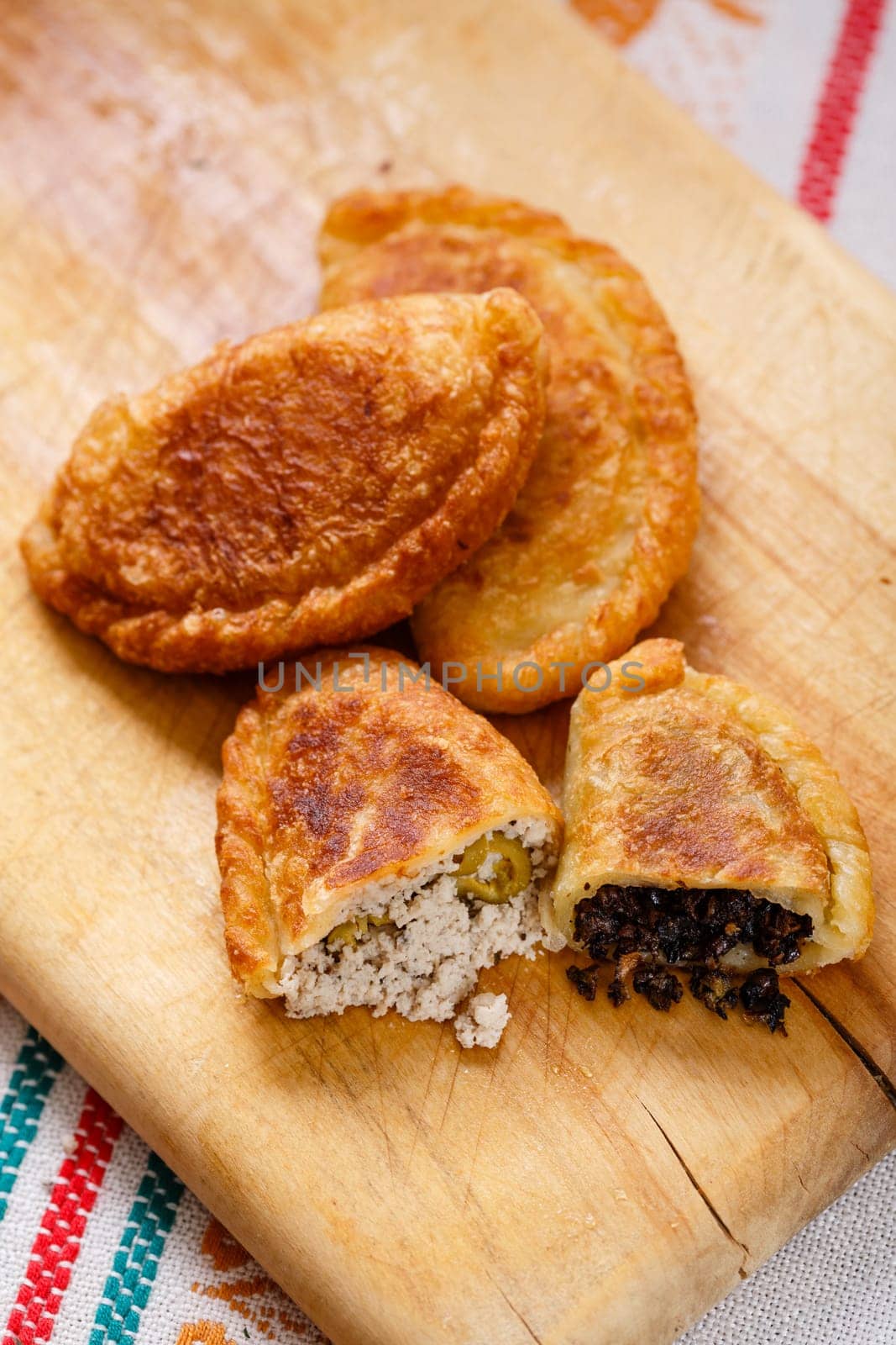 Colombian empanadas (snack sized savory patties) on wooden board. Latin cuisine