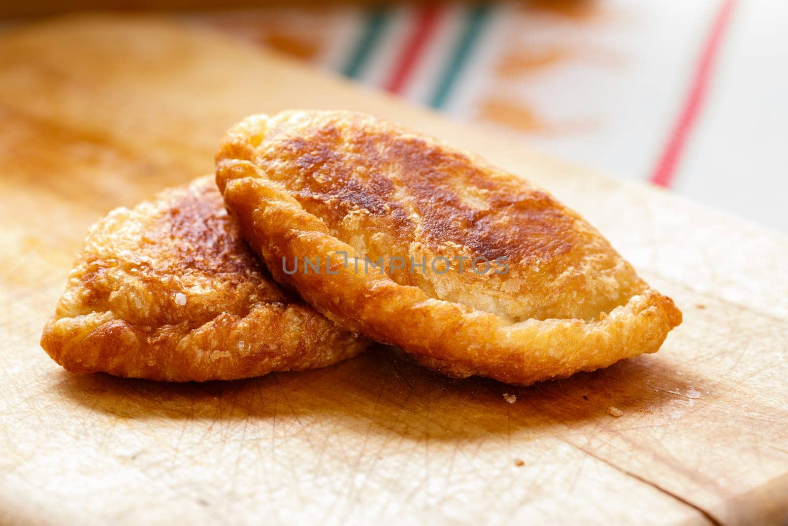 Colombian empanadas (snack sized savory patties) on wooden board. Latin cuisine