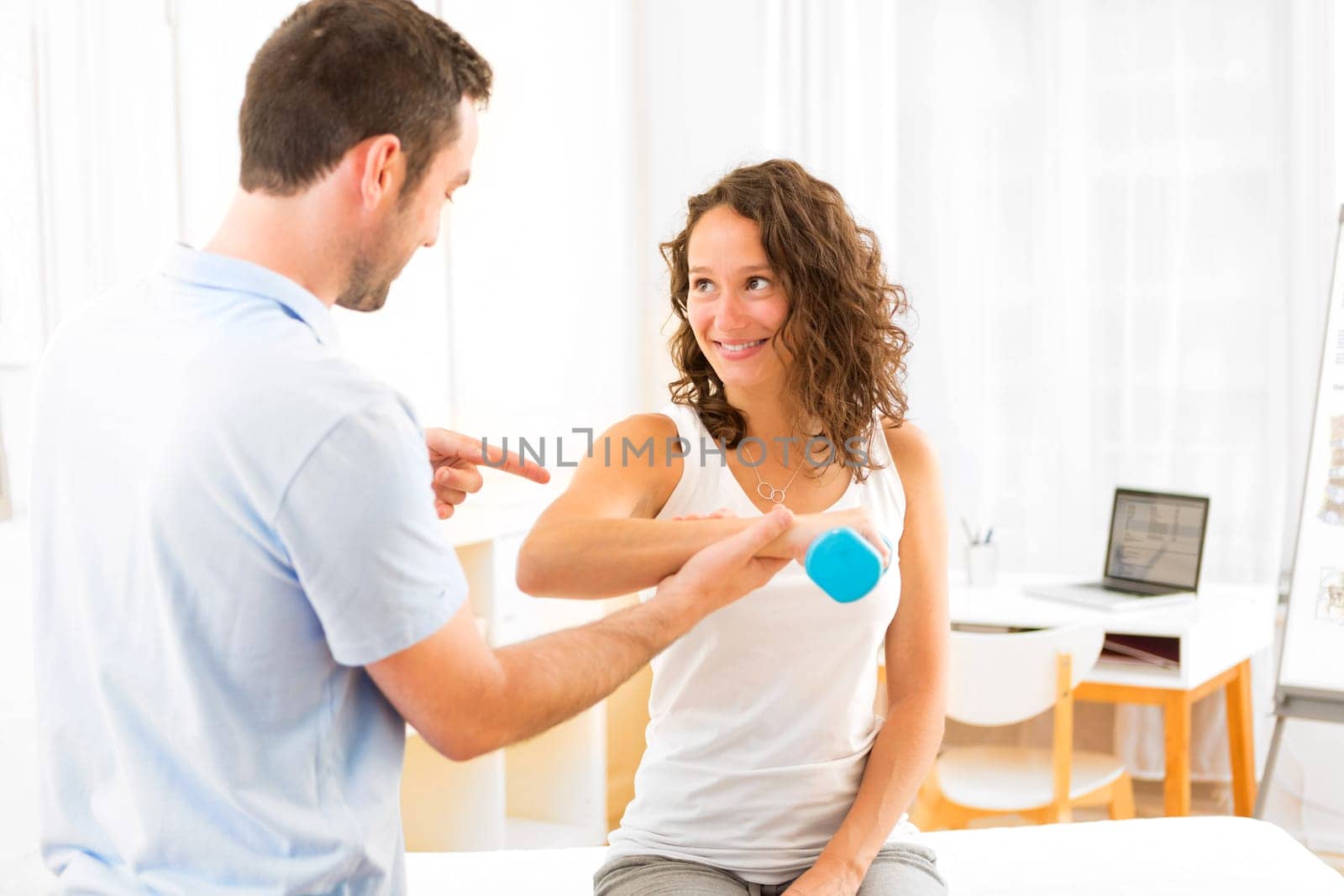 View of a Young attractive woman doing exercise with physiotherapist
