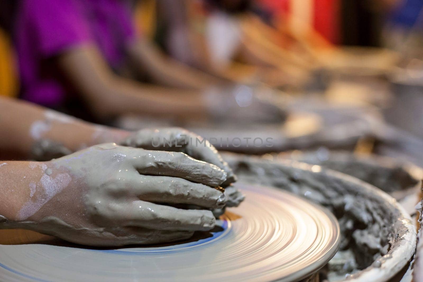 Children learning to work with potter's wheel