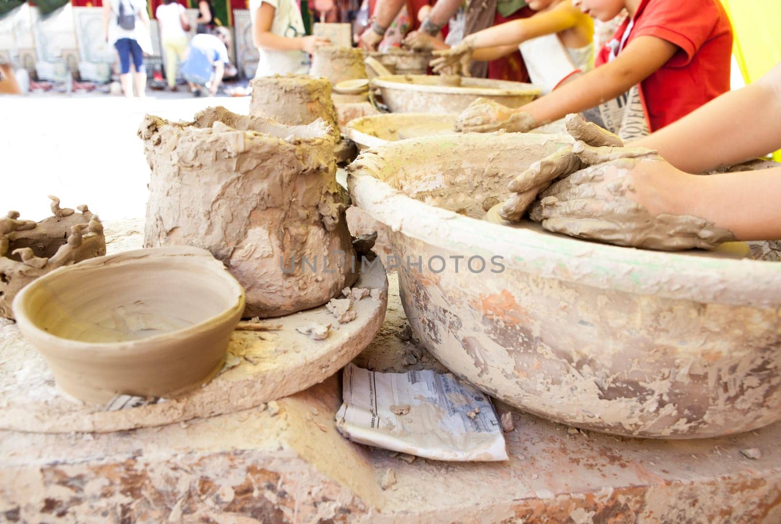 Children learning to work with potter's wheel