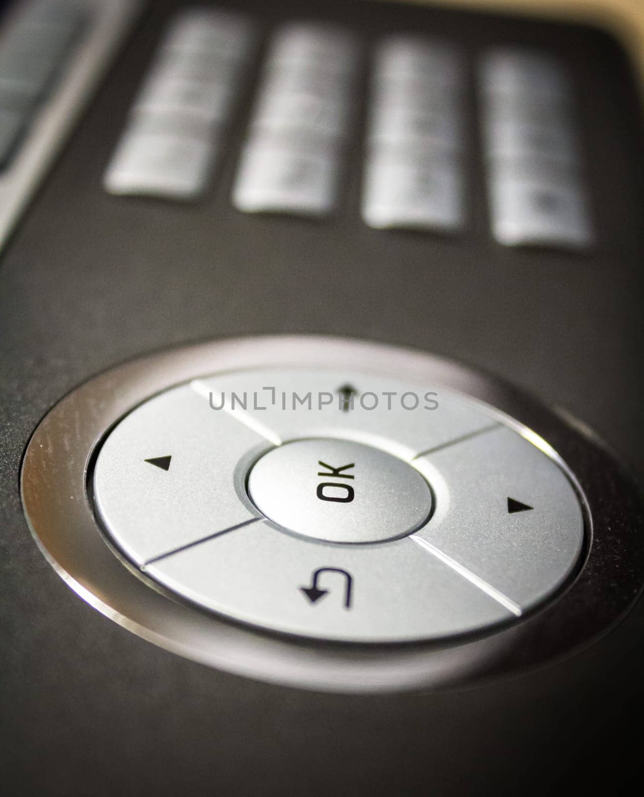 A grey phone with an OK button,close-up