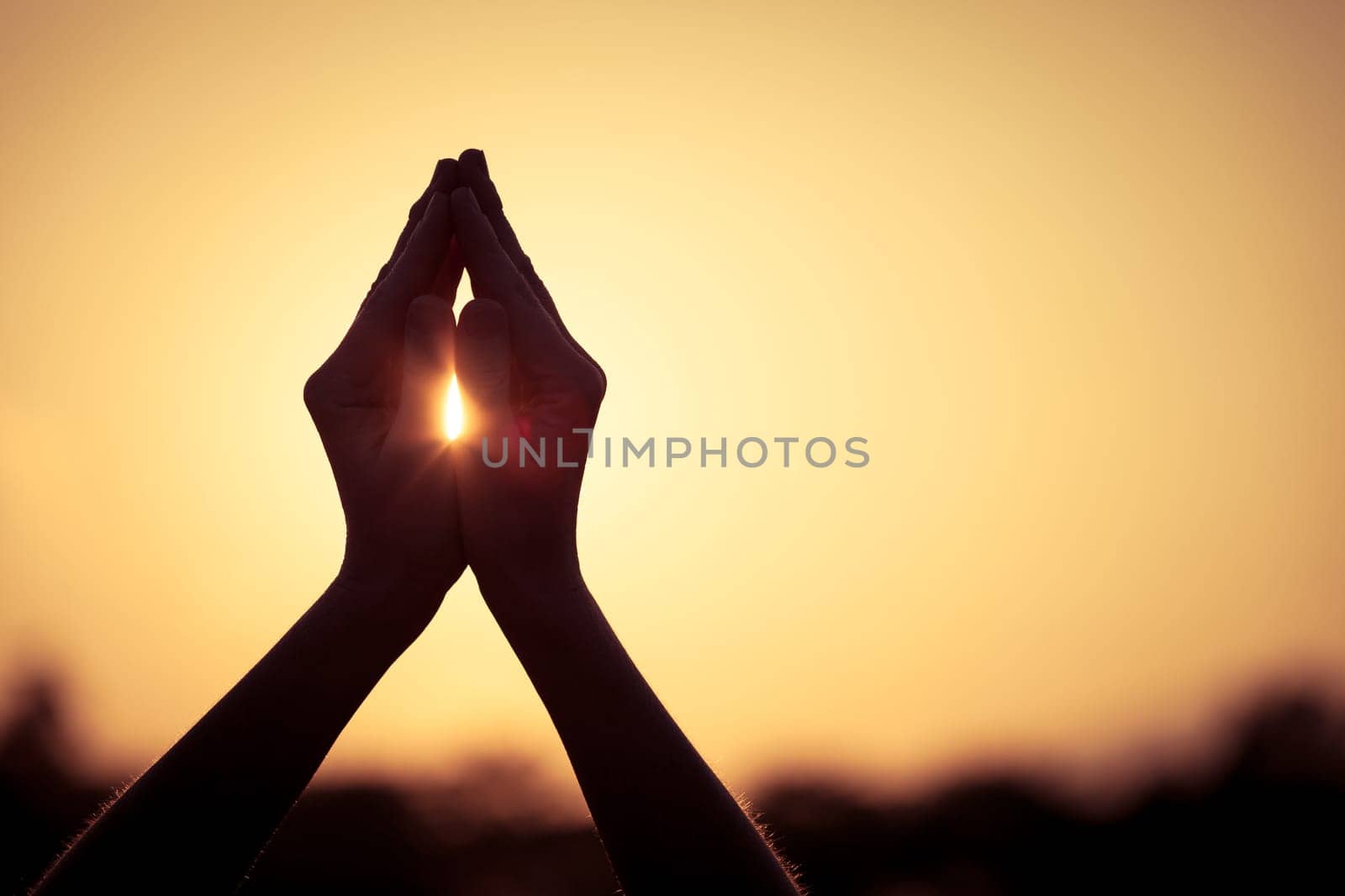 silhouette of female hands during sunset
