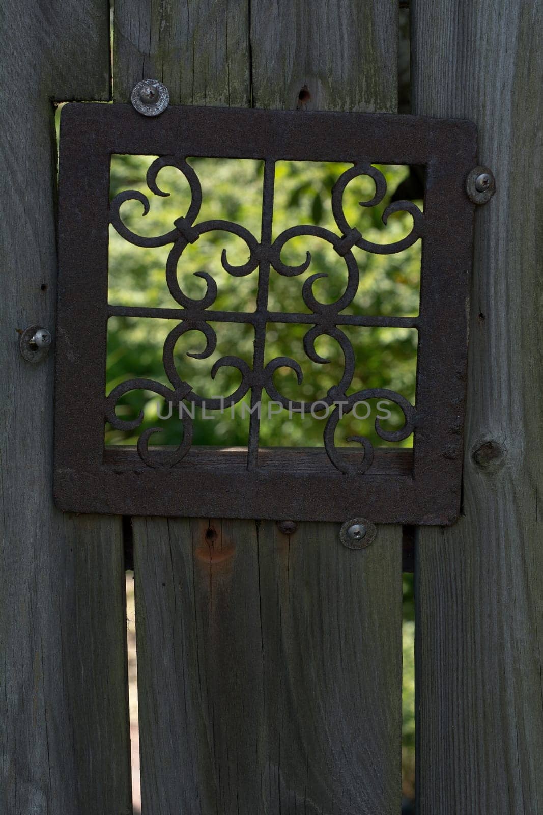 Old Fence with Metal Design Window Looking into the Garden