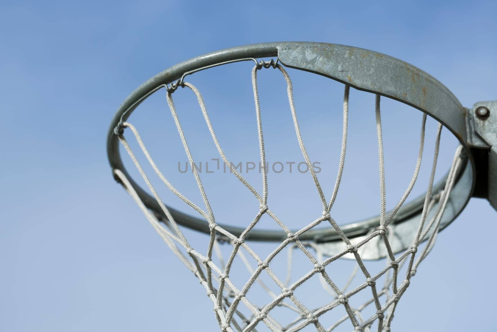 Basket Ball Hoop with blue sky behind it.