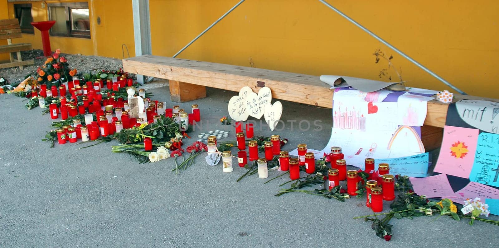 Wreaths with white ribbons take hold of last Monday's fire in Titisee-Neustadt. Fourteen people were killed in the workshop for the disabled. Candles,flowers and farewell letters at the Caritas workshop for the disabled