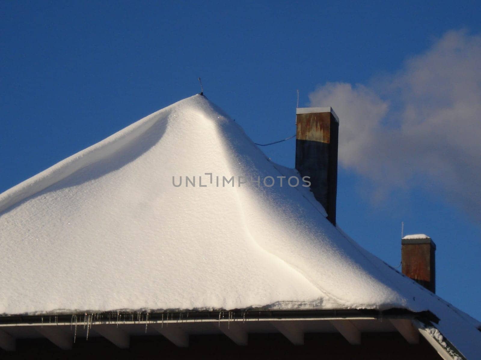 Smoking fireplace on a deep snow-covered roof - heating costs are rising again these days