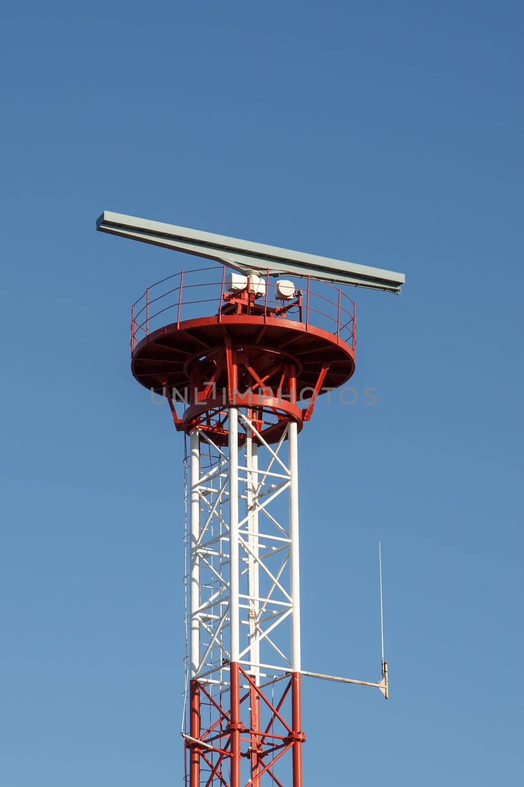 Tower with radar and antena against blue sky
