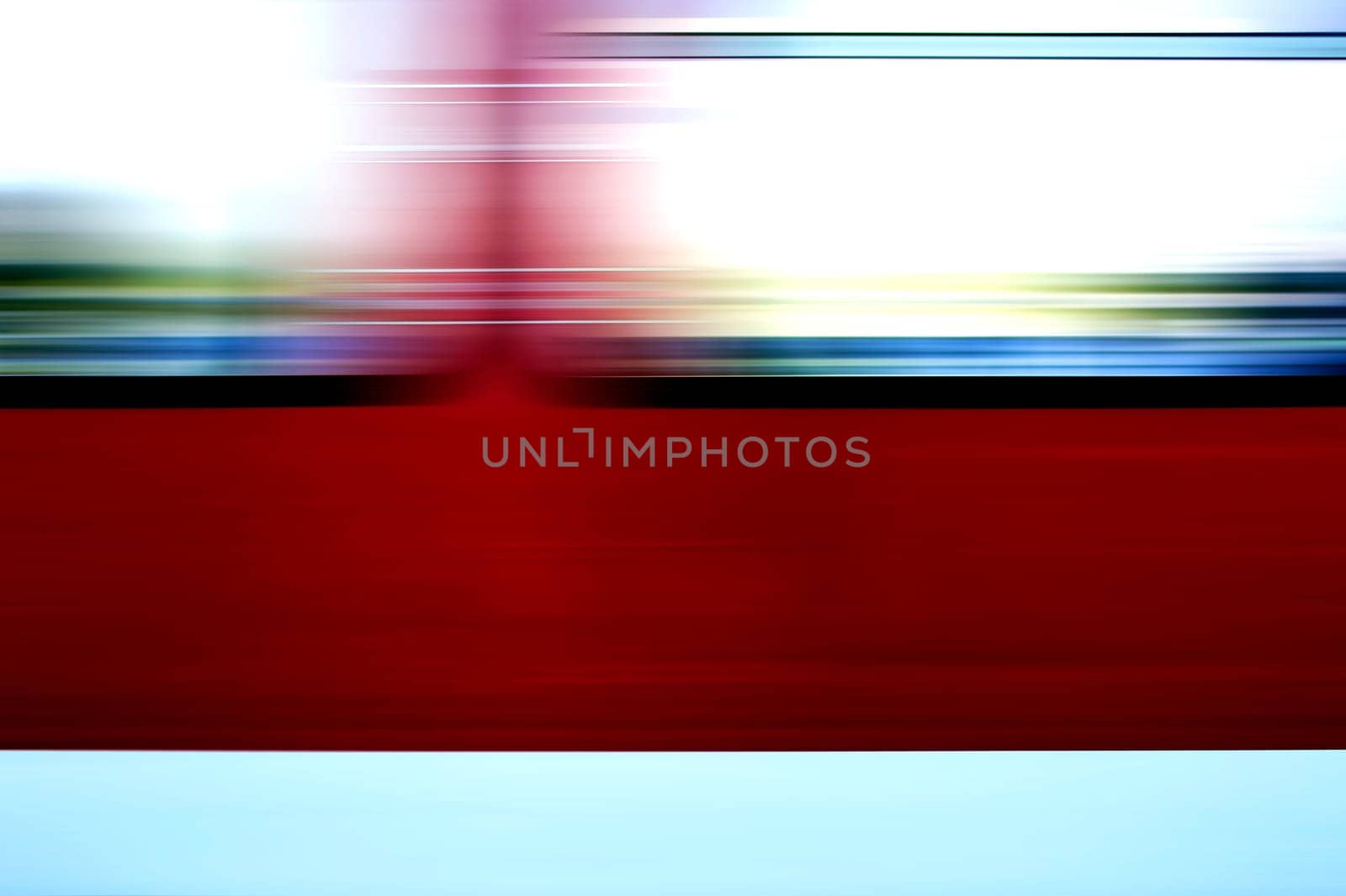 The abstract and colorful motion strips of the windows of a passing train.