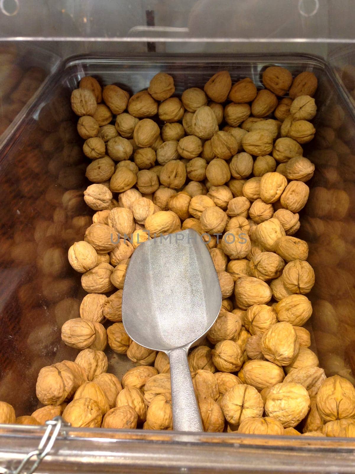 Box with different dry fruits on market with shovel for serve yourself