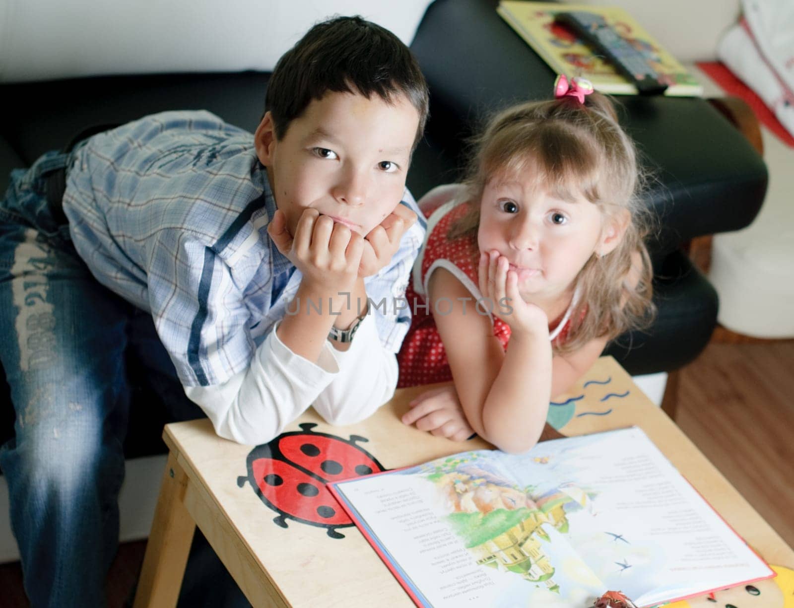 a little boy and girl, brother and sister, are reading a book
