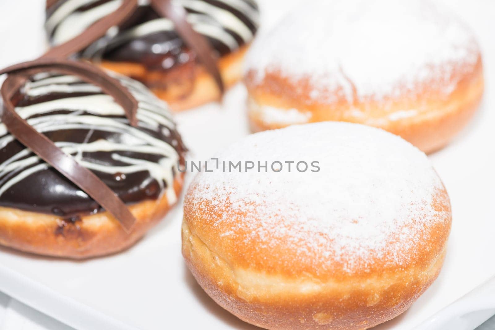 Chocolate and powdered sugar frosting donuts close up