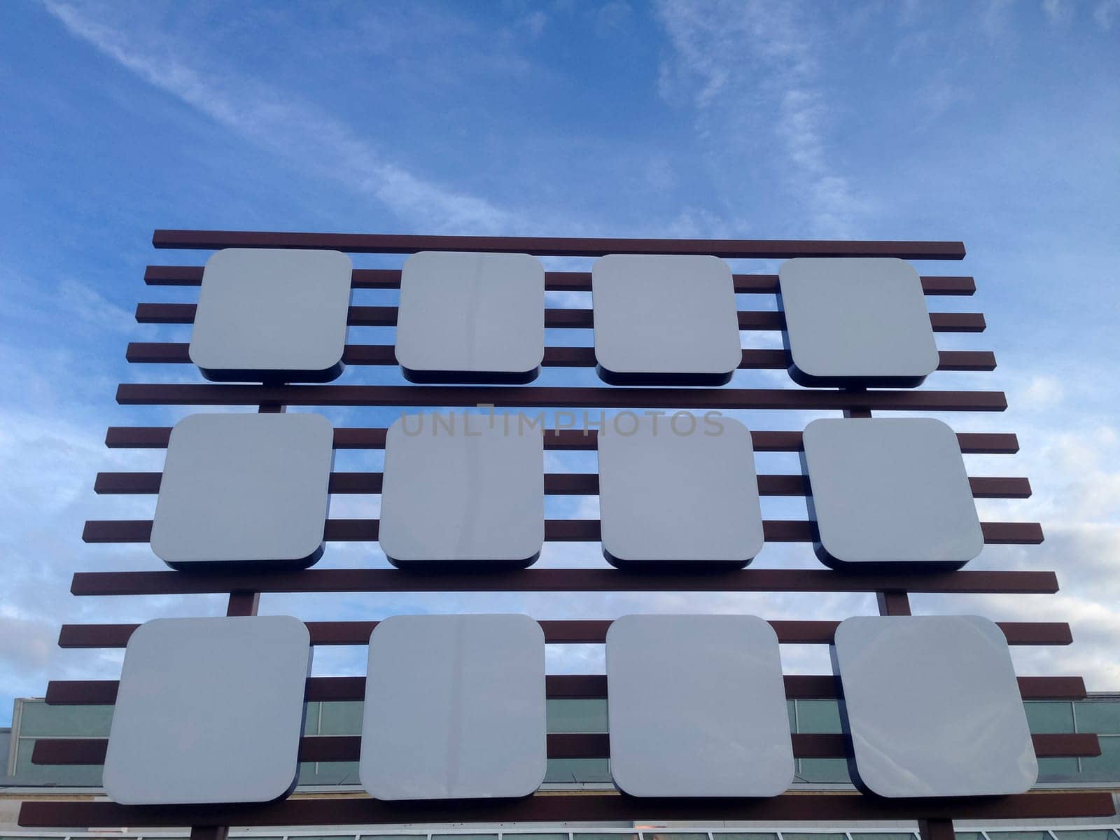 Empty big billboard at shopping mall, isolated over blue sky