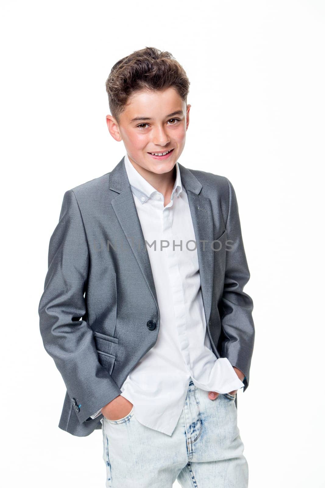 Happy young teenage boy dressed smartly on a white background. He is looking at the camera and smiling.