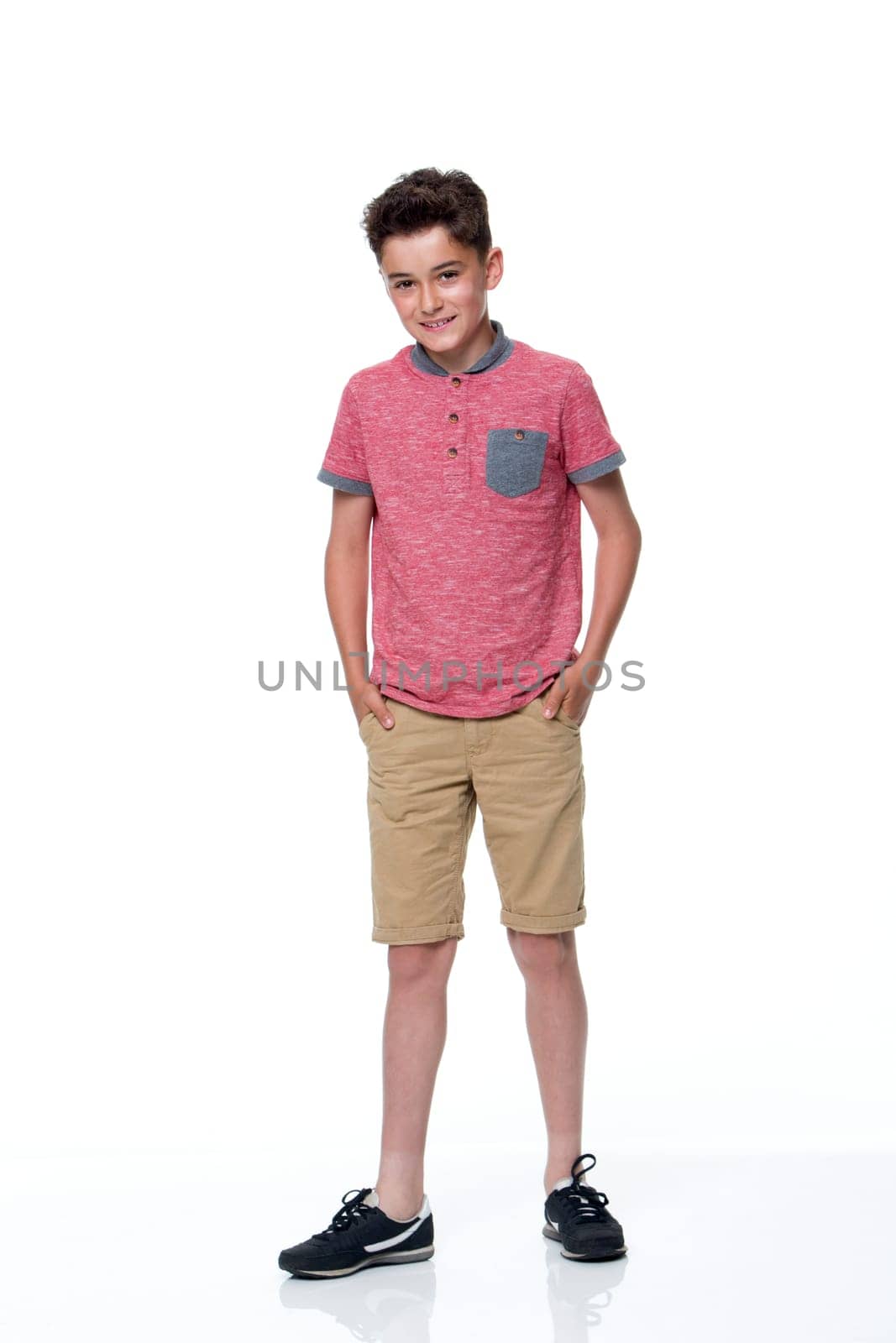 Young male dressed in casual clothing with a white background. he is looking at the camera and smiling.