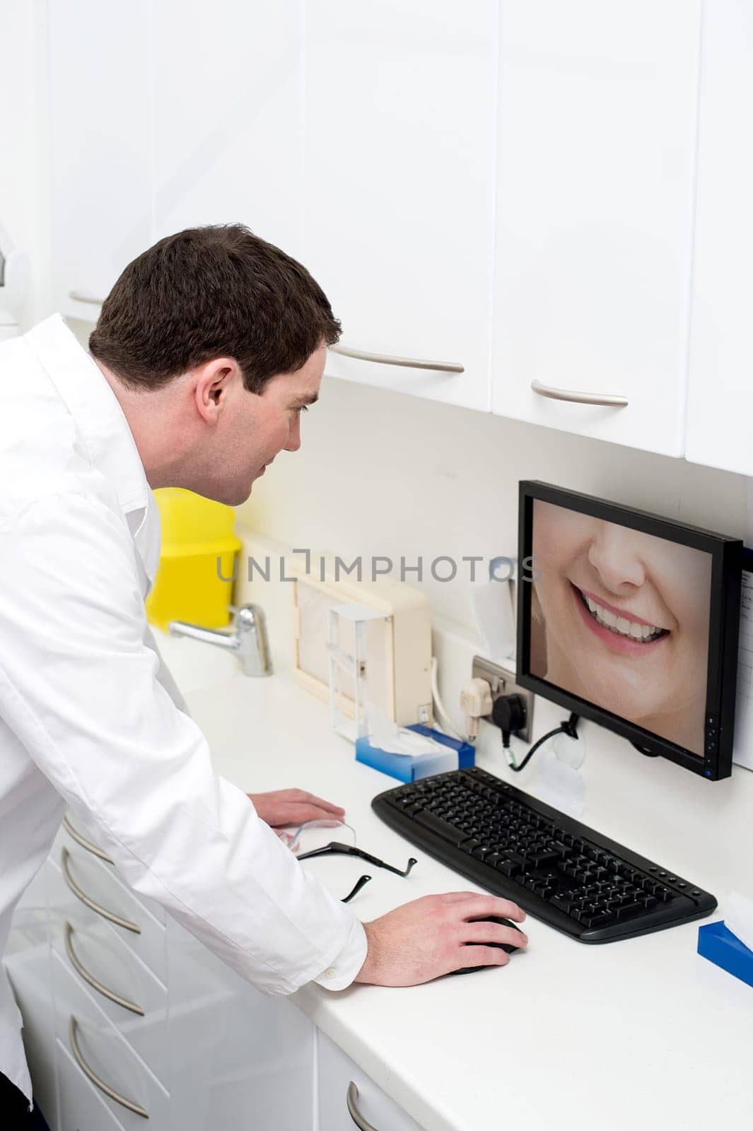 Image of a dentist checking patient teeth in monitor