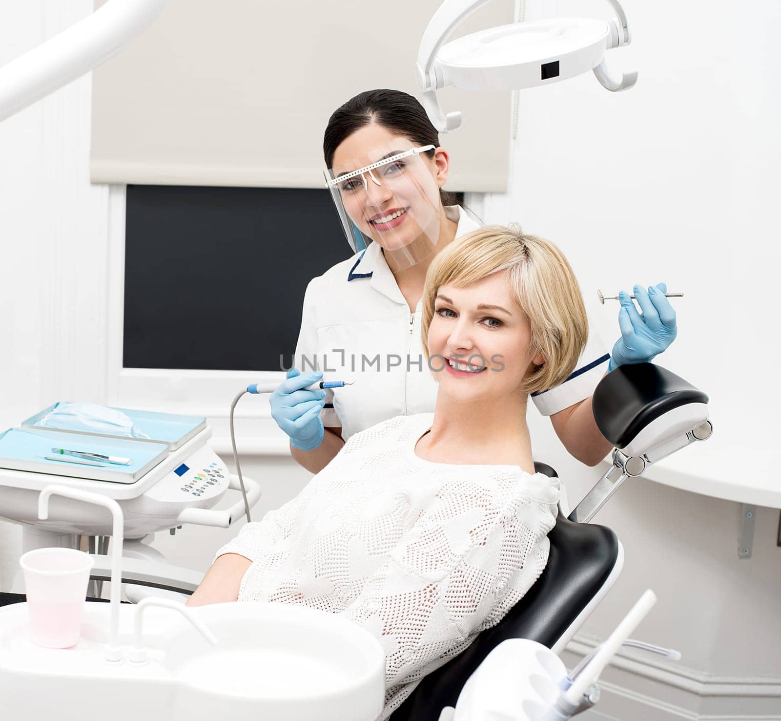 Female dentist and patient posing at dental clinic